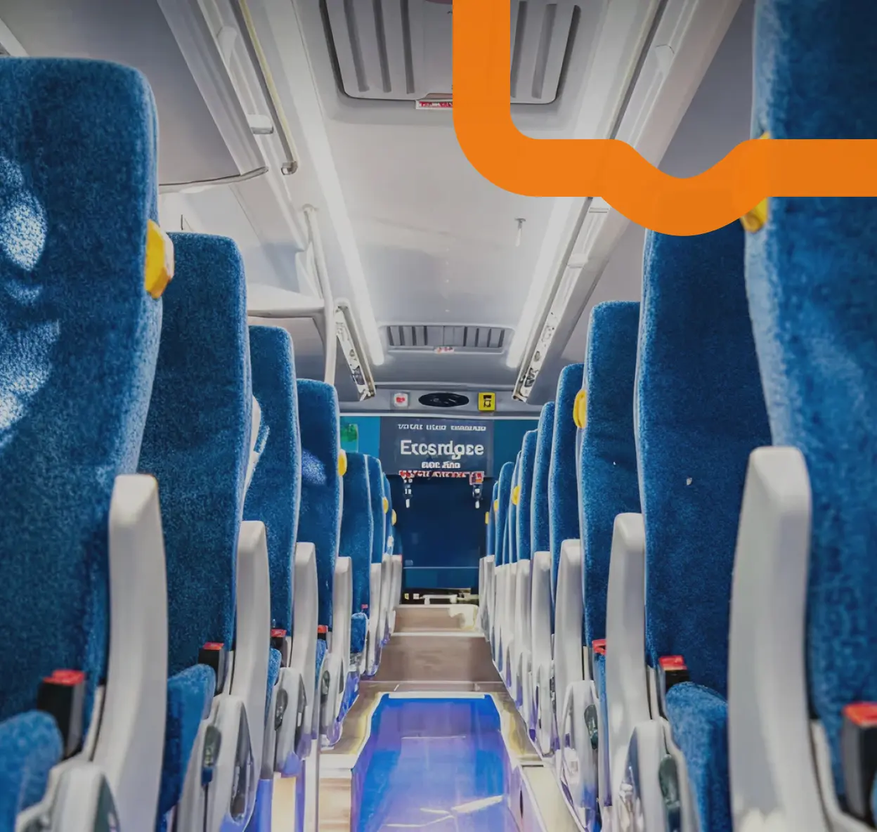 Interior view of a modern bus with blue upholstered seats and a clear aisle leading to the front door.
